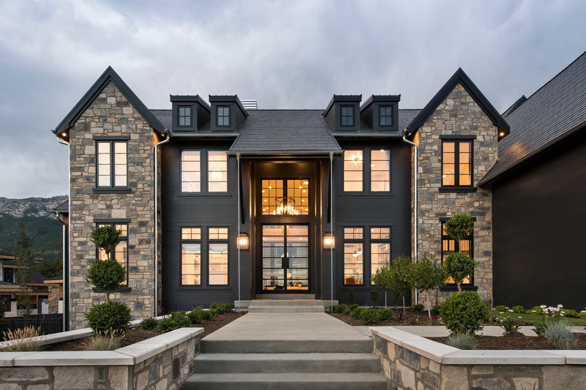 Black and stone house with Andersen A-Series windows. Photo by Andersen Windows.