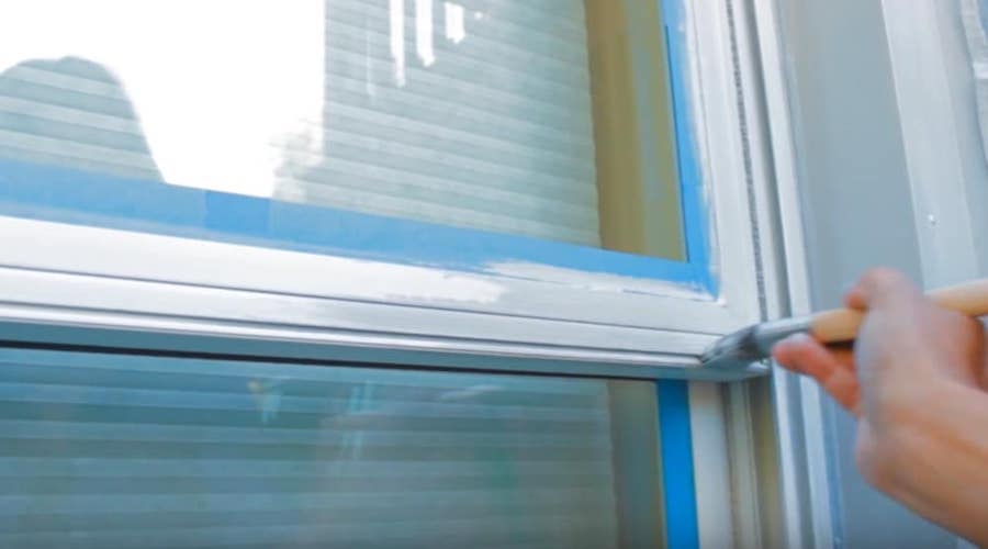 Someone painting vinyl windows from the exterior side. Image: WCMA NET