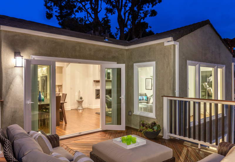 House with hinged patio doors open and patio furniture on the back deck