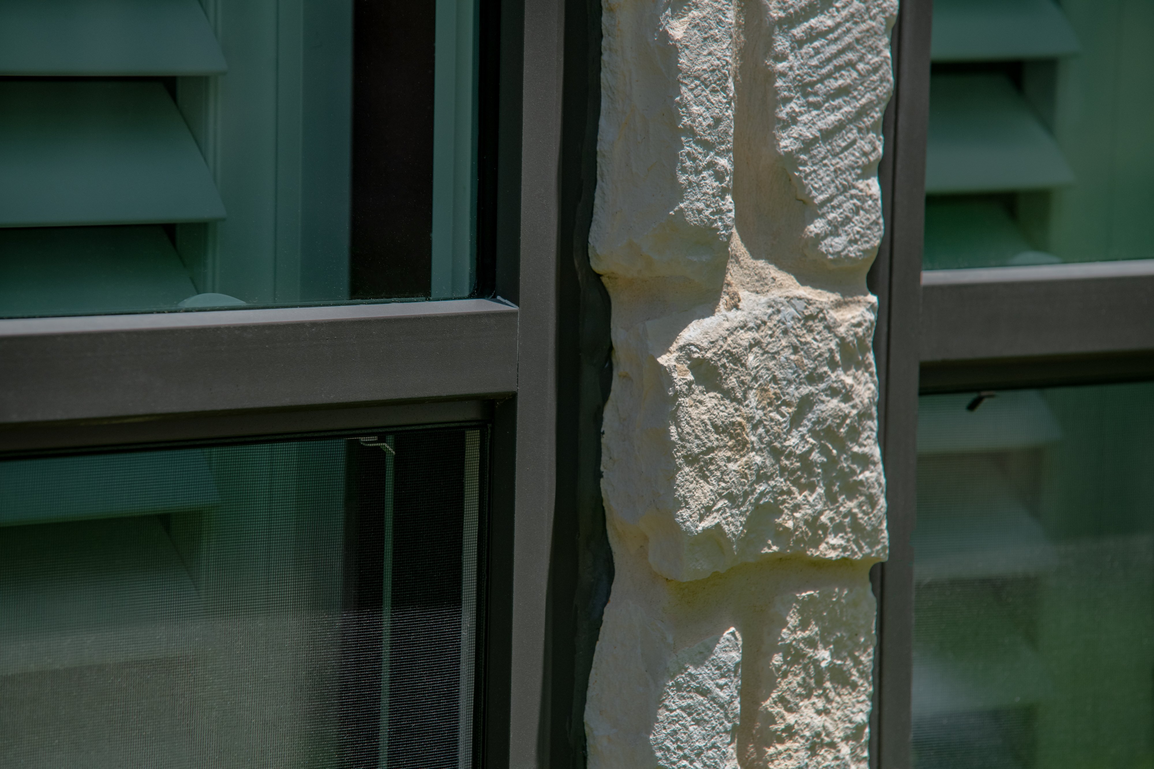 Bronze window in white stone close up