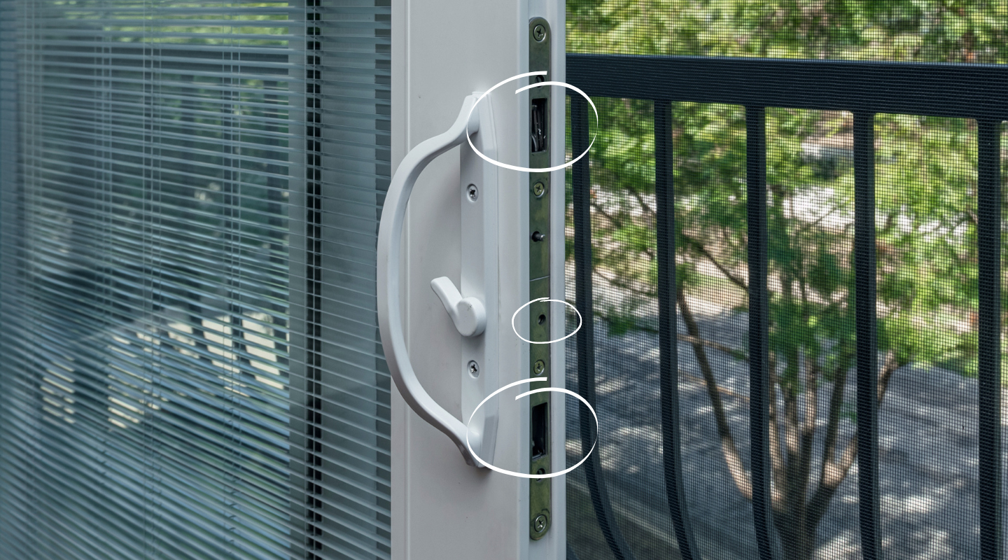 Photo of sliding door latch with circles around latch hook slots. Photo by Brennan.