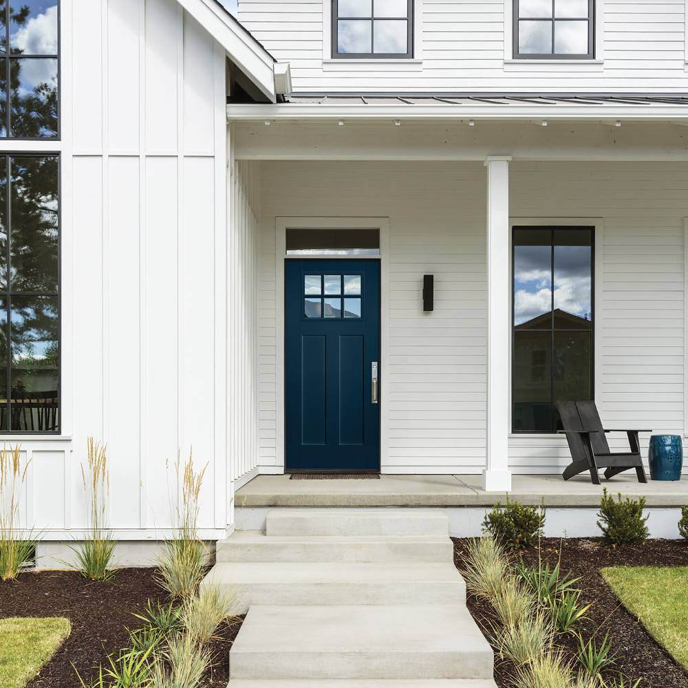 Dark blue door on white farmhouse style house
