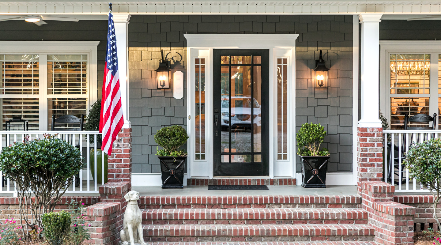 Gray house with white trim around windows and doors. Photo from Adobe Stock.