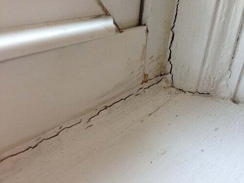Image of interior window frame corner with broken or cracked seals.