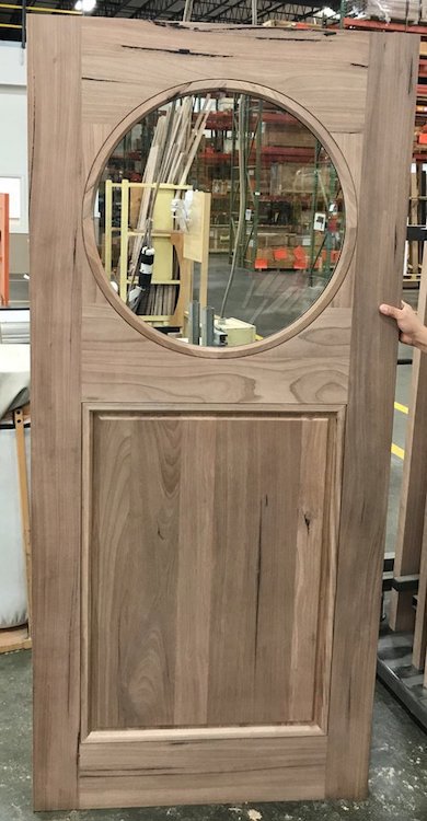 Custom wood door with circle cut in the center with clear glass.
