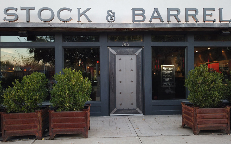 Outside view of Stock & Barrel with decorative steel front door, located in Bishop Arts District.