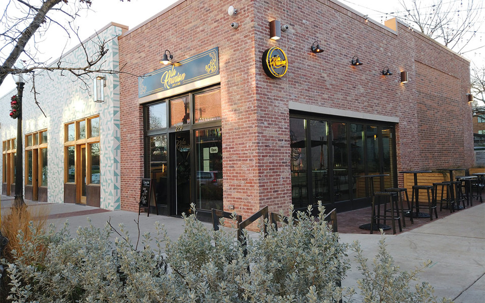 La Reunion cafe in Bishop Arts District has a brick storefront with black windows and doors including a folding door.