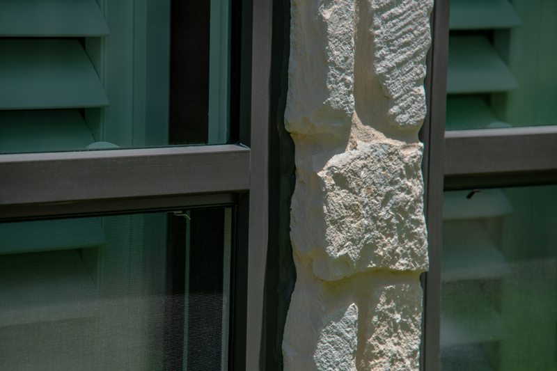 Bronze window in white stone close up