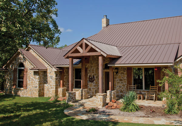 Mueller CF roof in bright copper on a stone home with wood trim.