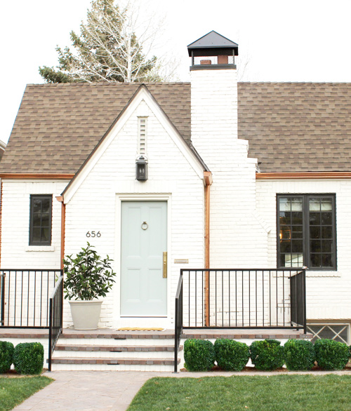 white brick with black railing and copper gutter