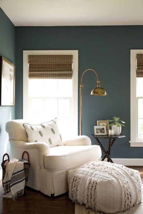 An oversized chair and ottoman in the corner of a room make for a cozy little reading nook.