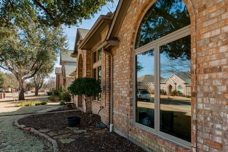 Brennan Enterprises installed these beautiful tan windows on a brick facade home. The windows have no grids and are topped with a curved radius window above two vertically proportional windows.