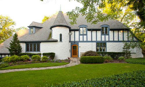 Example of a French Eclectic home with stucco exterior and rounded tower.