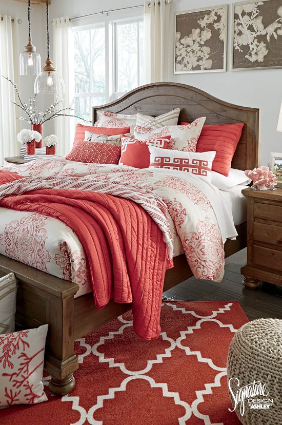 Neutral bedroom color palette with coral accents in the bedding, rug, and decor.