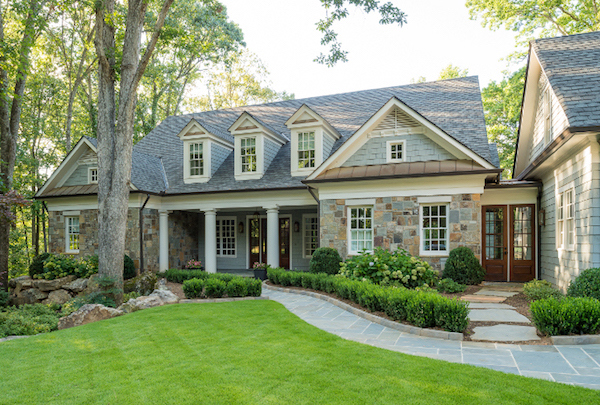 cape cod style house with staggered edge siding and stone exterior.