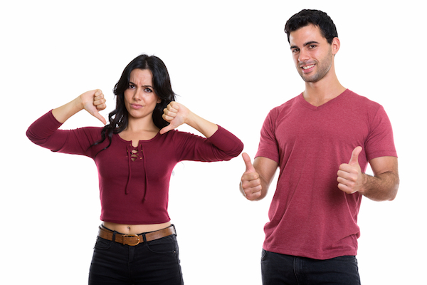 Woman with thumbs down and man with thumbs up